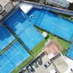 an aerial view of a tennis court and parking lot