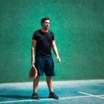 a man standing on a tennis court holding a racquet