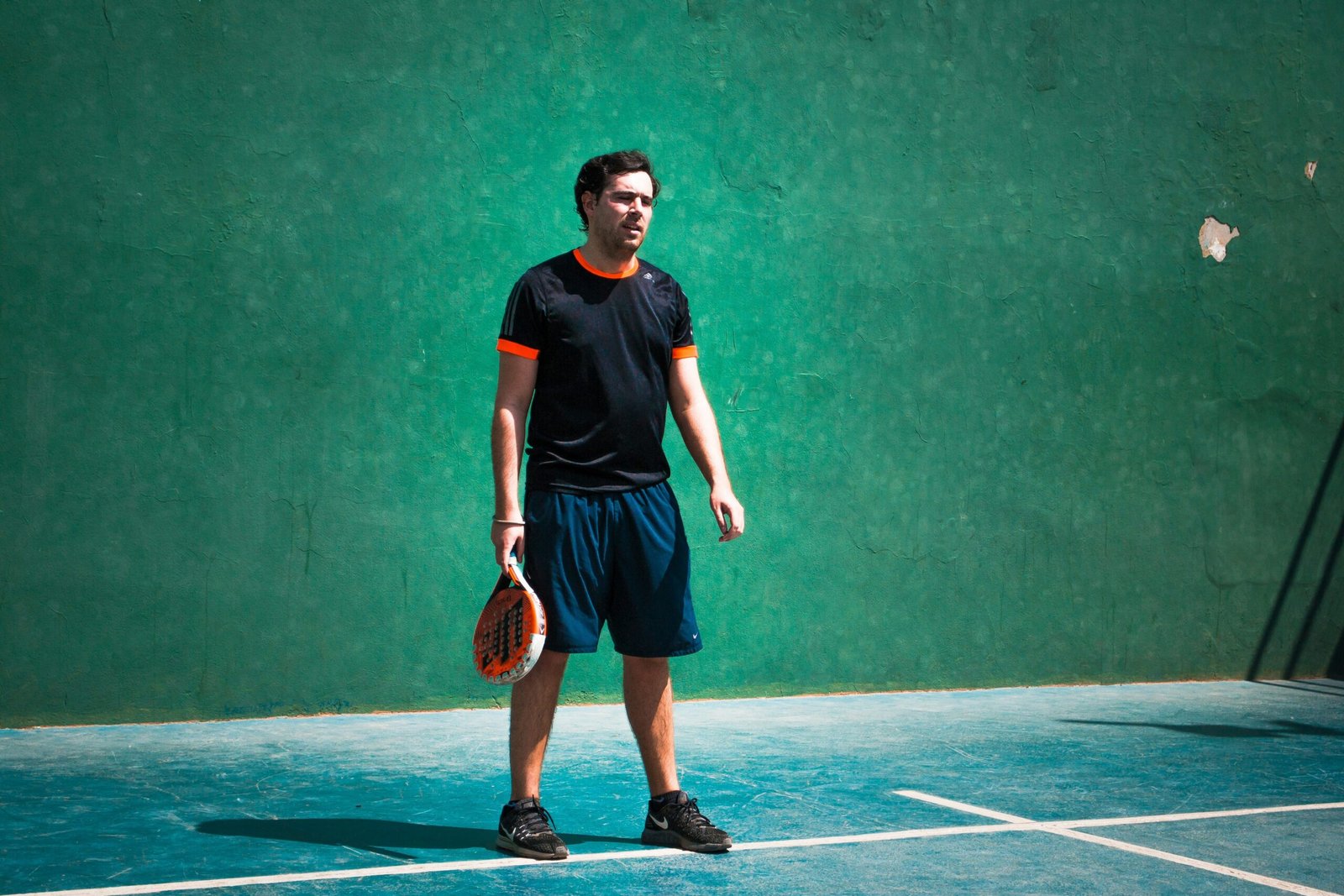 a man standing on a tennis court holding a racquet